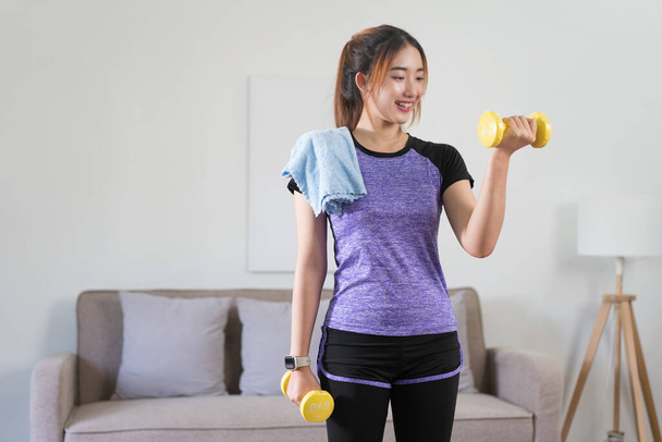 Jeune femme asiatique formation et faire de l'exercice pour soulever des haltères pour un mode de vie sain à la maison. - Photo, image