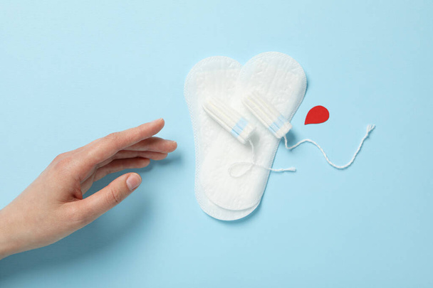 Tampons und Einlagen für Menstruationstage auf blauem Hintergrund - Foto, Bild