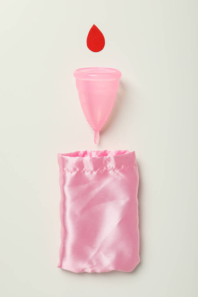 Menstruationstasse mit Tasche auf weißem Hintergrund - Foto, Bild