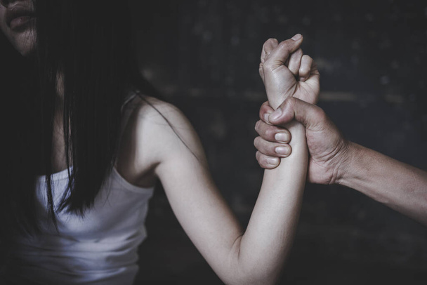 A férfi keze megragadja a nő karját. a nők elleni családon belüli erőszak, a családon belüli erőszak megállítása. A nők elleni szexuális zaklatás és a nemi erőszak fogalma. emberkereskedelem, nemzetközi nőnap.  - Fotó, kép