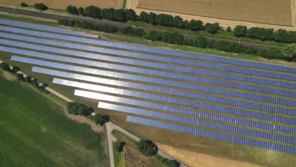 Zoom aereo su un parco solare a terra con pannelli solari per produrre energia rinnovabile, Darmstadt, Germania - Filmati, video