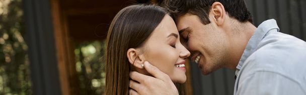 banner, happy man with closed eyes kissing girlfriend, vacation house, summer getaway, romance - 写真・画像