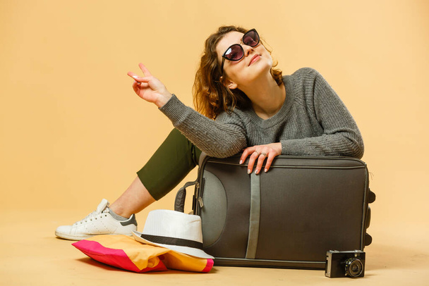 Viaggiatore donna con valigia su sfondo beige. - Foto, immagini