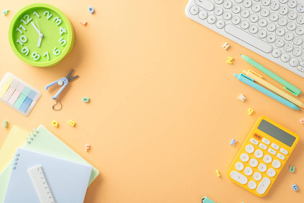 Foundation for learning. Overhead shot of stationery, calculator, sticky notes, computer and other supplies on a pastel orange background. Capture attention with your back-to-school advertisements - Fotografie, Obrázek