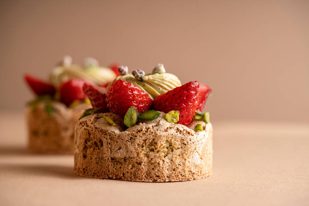 Pyszny deser składający się z dwóch dekadenckich ciastek truskawkowych i pistacjowych - Zdjęcie, obraz
