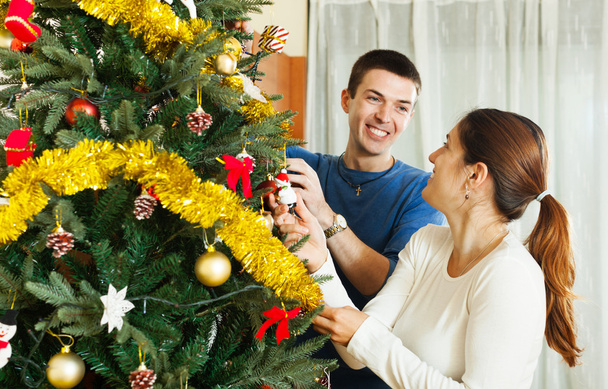 Couple decorating Christmas tree - Fotoğraf, Görsel
