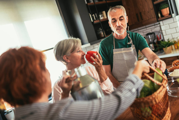 Happy mature middle-aged woman brings fresh vegetables and milk from country to her friends to make healthy dinner - Foto, Bild