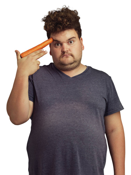 Plus size, carrot gun and man in portrait isolated on a transparent png background. Vegetables, carrots and sad person unhappy with diet, nutrition and vitamins, plants and food, health or wellness - Fotó, kép
