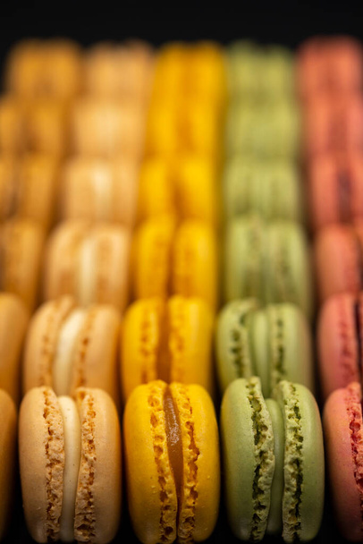 macaroons of different colors on a black background - Photo, image