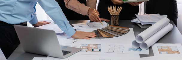Group of interior designer team in meeting, discussing with engineer on interior design and planning for house project blueprint and model, choosing various mood board materials. Insight - Photo, Image