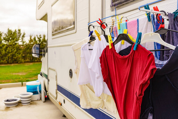 Clothes clean washing laundry hanging to dry on clothesline outdoor at caravan. Bowls and wash machine in the background. Camping, vacation trip. - Φωτογραφία, εικόνα