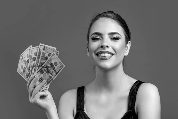 Luxury, beauty and money concept. Woman with dollars in hand. Portrait woman holding money banknotes. Black and white. - Foto, Imagem