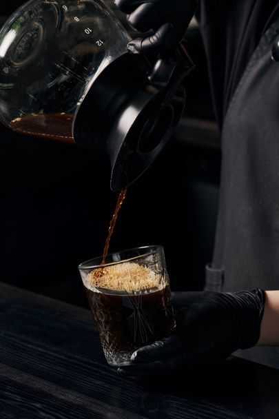 barista pouring aromatic espresso from coffee pot into crystal glass, alternative brewing method - Zdjęcie, obraz