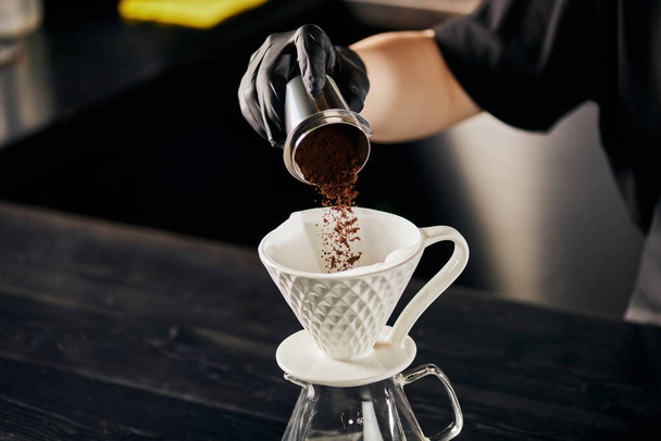 barista verter café molido fino de jigger en gotero de cerámica, preparando V-60 estilo espresso - Foto, imagen