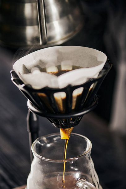 tuore espresso tippuu lasikahvipannussa paperisuodattimesta tiputustelineessä, V-60-tyylinen menetelmä - Valokuva, kuva