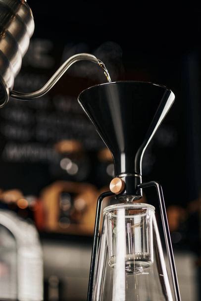 siphon coffee maker and boiling water pouring from drip kettle during preparation, pour-over espresso - Photo, Image