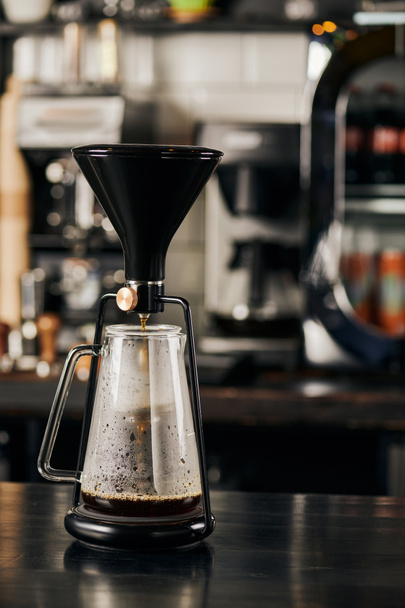 Sifon kahve makinesi, cam kahve demliğinde taze espresso modern kafede, siyah ahşap masada. - Fotoğraf, Görsel