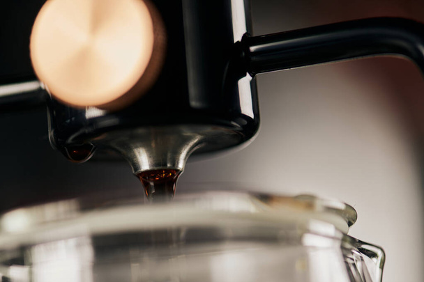 vista de cerca del espresso recién hecho goteando de la cafetera de sifón, borroso primer plano - Foto, Imagen