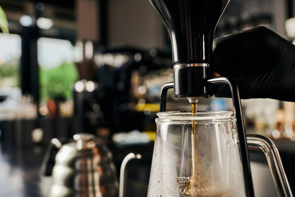 partial view of barista regulating siphon coffee maker while brewing espresso in coffee shop - Photo, Image