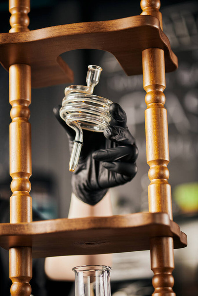 barista σε μαύρο γάντι κρατώντας σπιράλ μέρος του κρύου καφέ ετοιμάζω, εναλλακτική μέθοδος espresso - Φωτογραφία, εικόνα