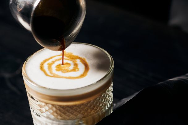 Латте маккиато, наливая эспрессо в стекло, кувшин с кофе, молочная пена, энергия и кофеин  - Фото, изображение
