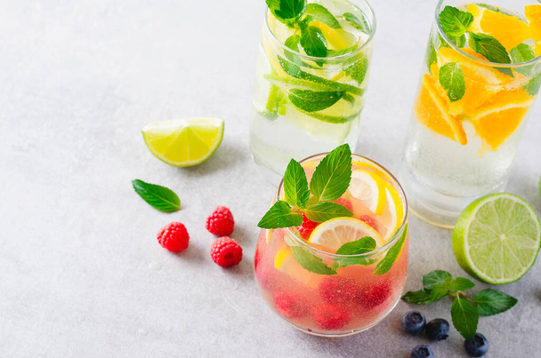 Ensemble de boissons estivales, fruits, agrumes et fruits rafraîchissants Citronnades ou cocktails sur fond lumineux - Photo, image