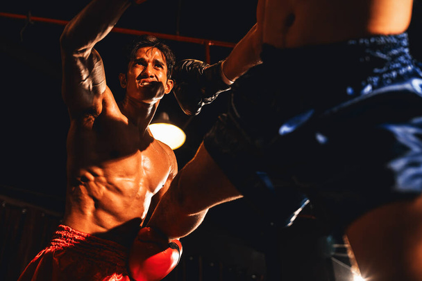 Le boxeur asiatique et caucasien Muay Thai libère son pouvoir dans un match de boxe féroce. Deux boxeurs MuayThai avec un corps musclé fort échangeant poinçon et frapper avec des prouesses de combat implacables. Impulsion - Photo, image