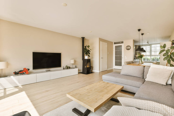 гостиная с диванами и телевизором на стене перед диваном деревянный пол - Фото, изображение