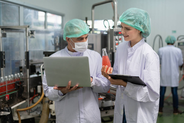 quality supervisor or food or beverages technician discuss about process control of food and drugs before send product to the customer. Production leader recheck ingredient and productivity. - Fotografie, Obrázek