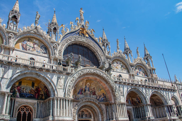 Details of St Mark's Basilica or the Basilica di San Marco in Italian, golden mosaics, intricate carvings, and statues adorn the roof of St. Mark's Basilica, a true marvel of Byzantine art in Venice. - Fotó, kép