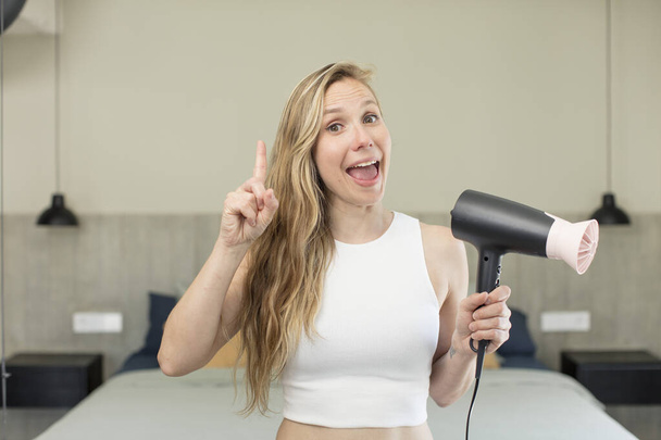 feeling like a happy and excited genius after realizing an idea. hair dryer concept - Foto, afbeelding