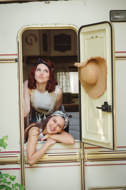 Glückliche Hippie-Freunde amüsieren sich gemeinsam in einem Wohnwagen. Urlaub, Urlaub, Reisekonzept. Hochwertiges Foto - Foto, Bild