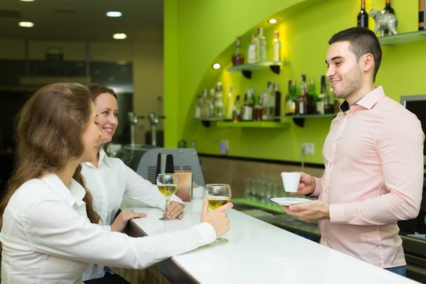 Barman i uśmiechający się kobiety w barze - Zdjęcie, obraz