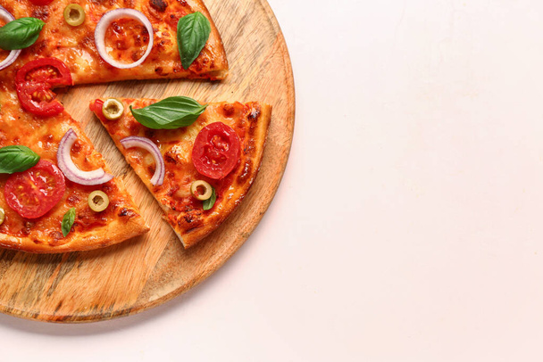 Tablero con sabrosa pizza sobre fondo beige - Foto, Imagen