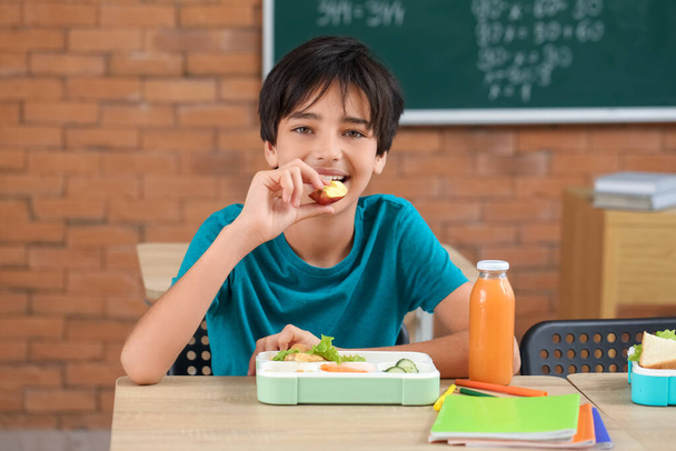 Little boy eating lunch in classroom - Фото, изображение
