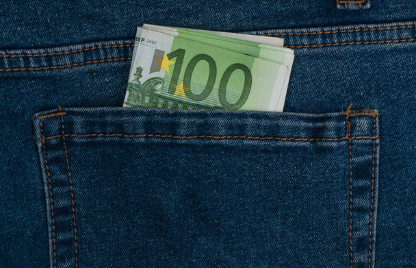 Honderd eurobiljetten in de zak van een close-up van een blauwe jeans - Foto, afbeelding