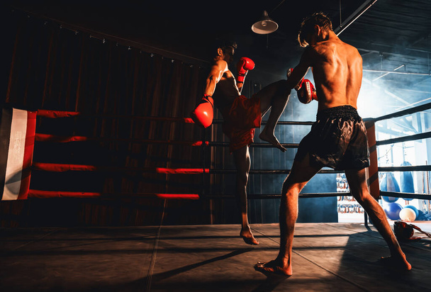 Azjatycki i kaukaski bokser Muay Thai uwalnia atak kolana w zaciętej sesji treningowej boksu, dostarczając uderzenie kolana sparingowemu trenerowi, pokazując technikę i umiejętności boksu Muay Thai. Impetus - Zdjęcie, obraz