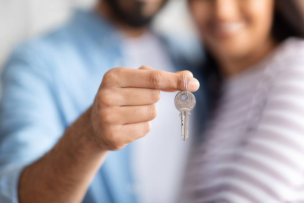 Unrecognizable young couple at new home hold house keys moving in together, loving caring husband and wife apartment owners excited relocating to own dwelling, renting, relocation concept - Foto, Bild