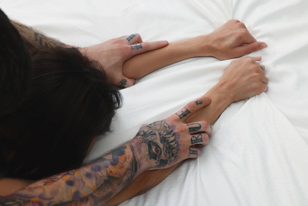 Passionate couple having sex on bed, closeup of hands - Fotó, kép