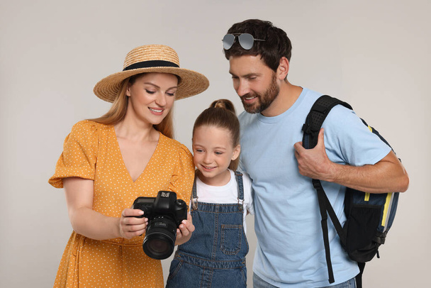 Happy family looking into camera on light grey background - Фото, изображение