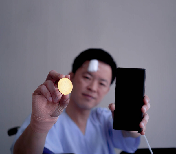 Asian man showing crypto and smart phone accident injure healthy investment risk managment - Photo, Image