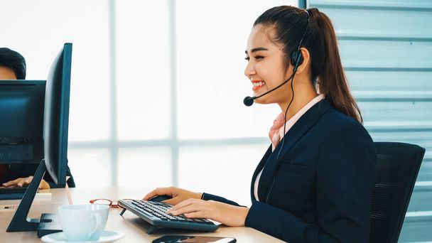 Business people wearing headset working in office to support remote customer or colleague. Call center, telemarketing, customer support agent provide service on telephone video conference call. Jivy - Фото, зображення