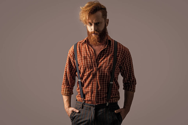 photo of charismatic retro hipster man in suspenders. retro hipster man in suspenders isolated on grey. retro hipster man in suspenders at studio. retro hipster man in suspenders on background. - Fotografie, Obrázek