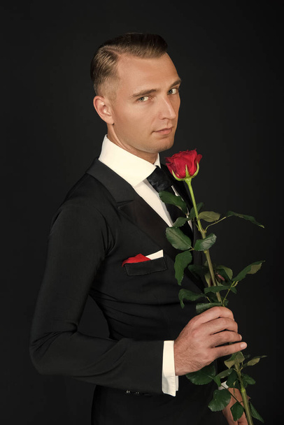 tuxedo man at valentines day. tuxedo man hold valentines rose. love occasion for valentines tuxedo man. photo of tuxedo man at valentines day. - Фото, зображення