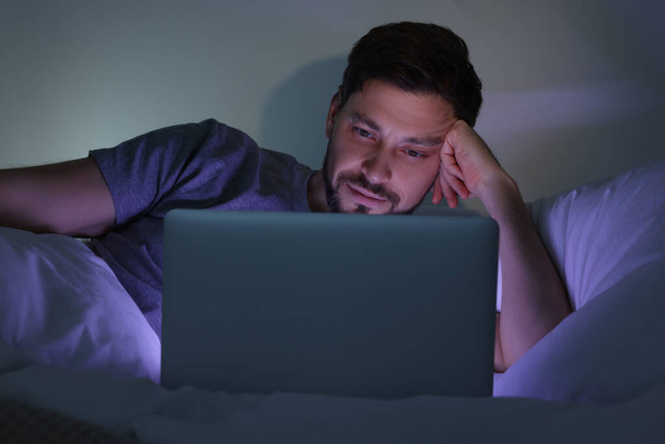 Man using laptop in bed at night. Internet addiction - Foto, Imagem