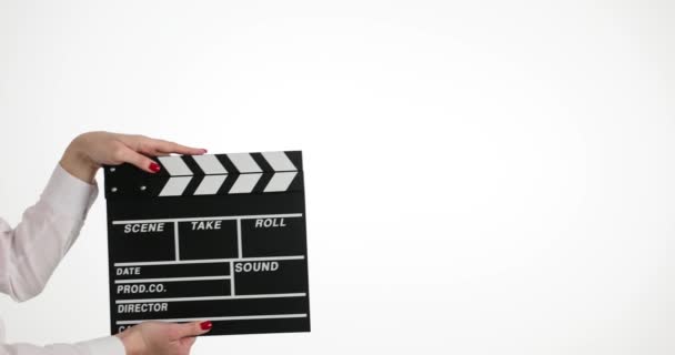 Női kéz klip segítségével fekete clapboard, hogy jelet, hogy elkezd forgatni film. Női asszisztens elszigetelt fehér háttérrel a forgatás alatt - Felvétel, videó