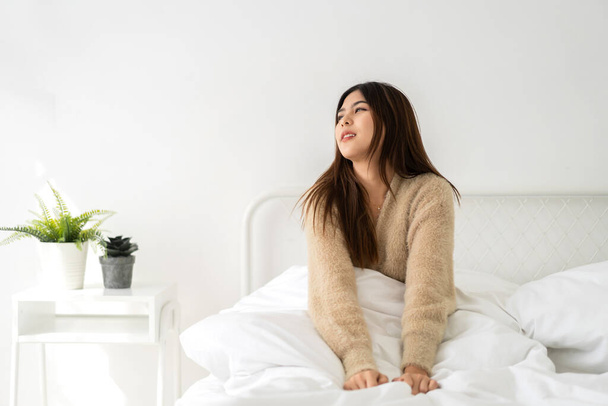 Portret van lachende vrolijke mooie mooie Aziatische vrouw schoon frisse gezonde witte huid poseren glimlach in pyjama 's.Girl kappen ontspannen en genieten van tijd op het bed thuis.azië schoonheid - Foto, afbeelding