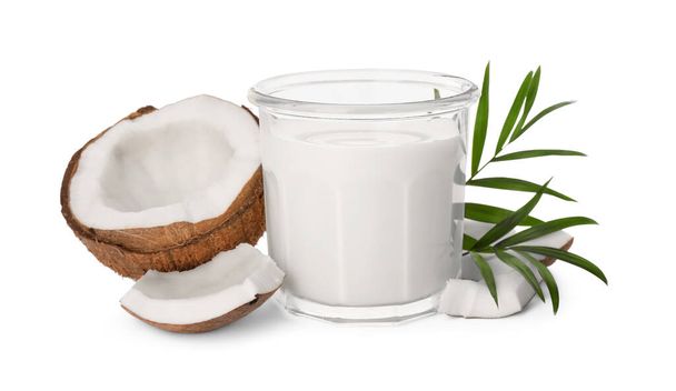 Glass of delicious vegan milk, coconut pieces and green leaves on white background - Valokuva, kuva