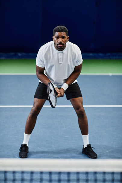 Retrato de comprimento total de desportista preto profissional jogando tênis na quadra interna - Foto, Imagem