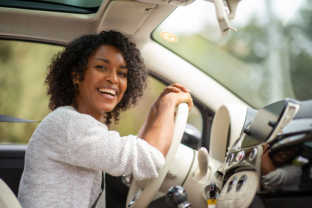 Портрет щасливої молодої афроамериканки, що їде в машині - Фото, зображення